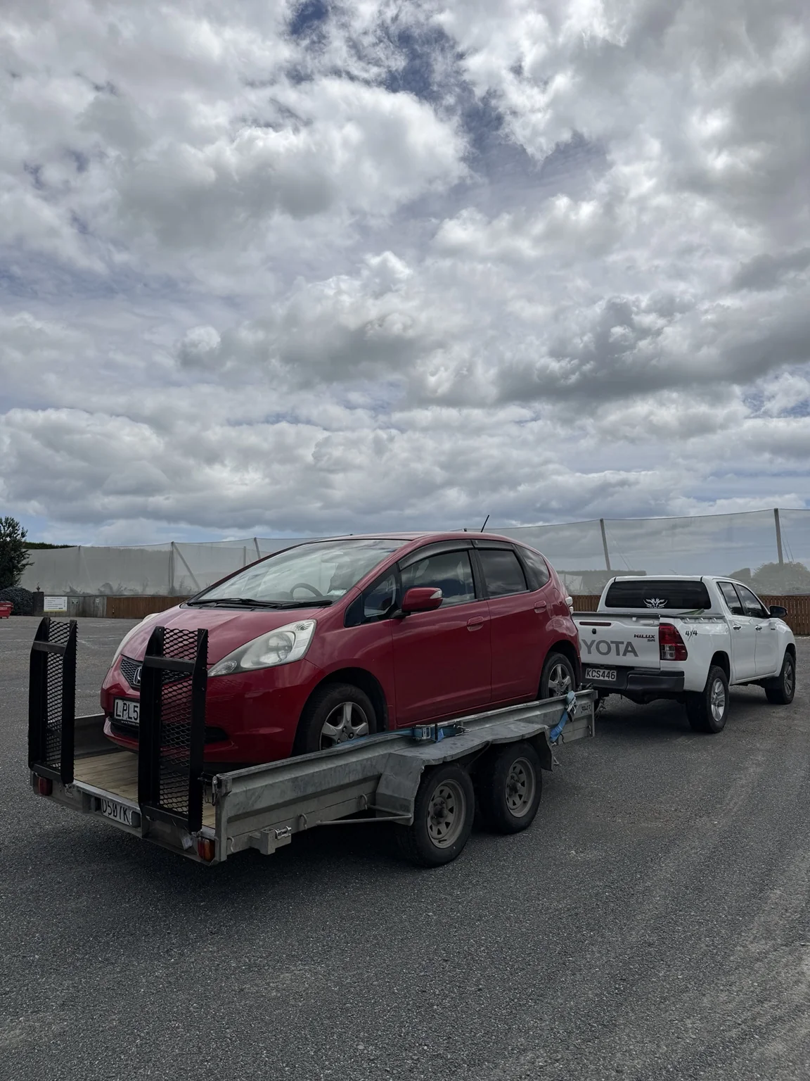 Small car secured on TUT Transport open transport trailer